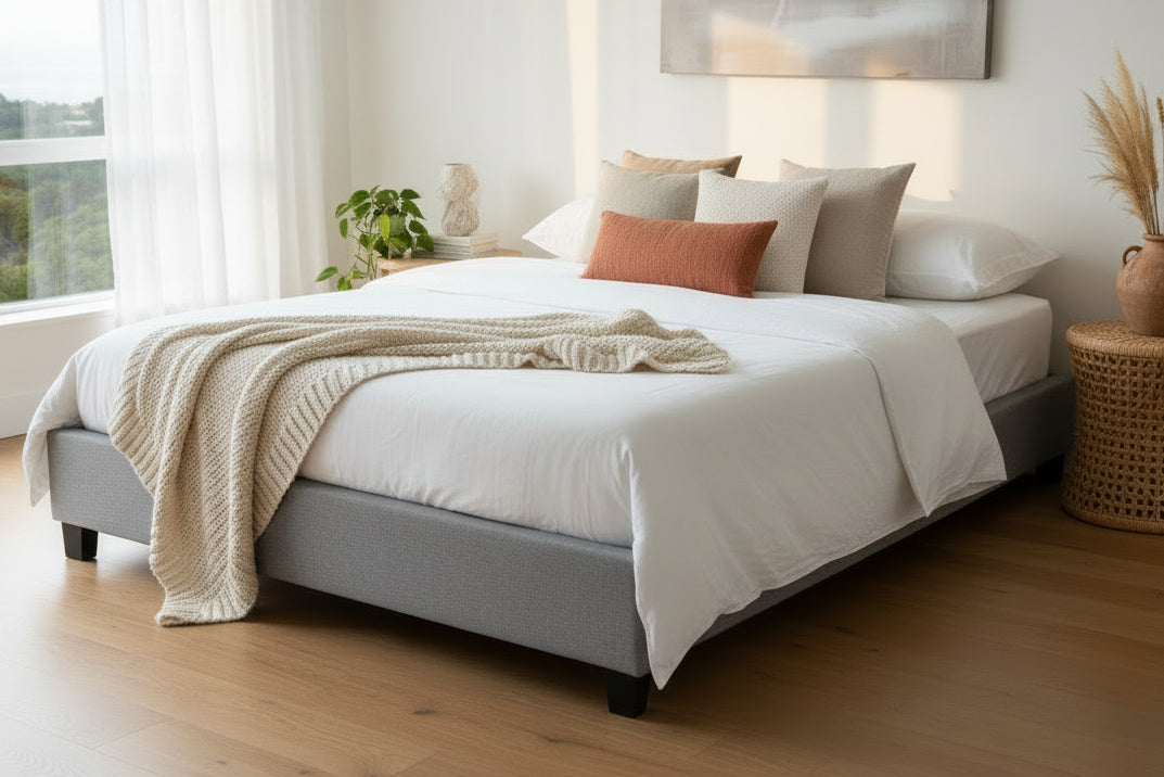 Sand upholstered bed frame with wooden slats on a white background