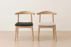 Two wooden chairs with cushioned seats on a light wooden floor.