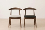 Two wooden chairs with cushioned seats on a light wooden floor.
