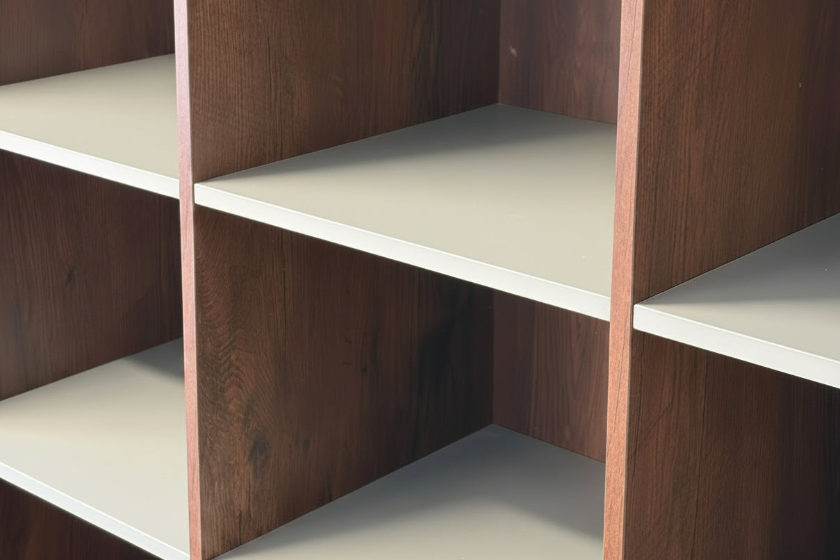 Close-up of a modular shelving unit with dark brown wood grain side panels and light beige shelves.