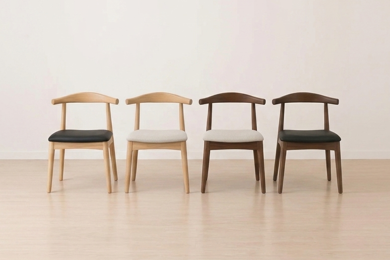 Four wooden chairs with leather and friable cushion seats arranged in a row on a light wooden floor.