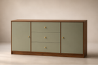 A mid-century modern sideboard cabinet with sage green panels and a warm brown wood frame, featuring three drawers in the center and small round brass knobs.