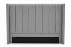 A gray upholstered headboard with vertical channel tufting and a black panel at the base, shown against a plain white background.