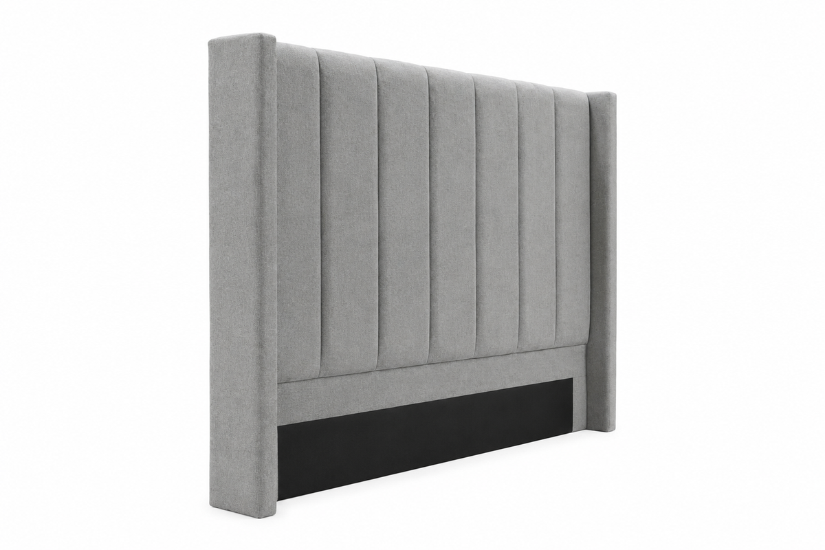 A light gray upholstered headboard with vertical channel tufting and a black panel at the base, shown on a plain white background.