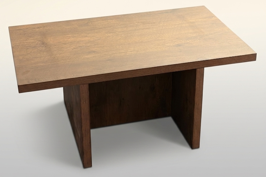 A rectangular wooden table with a medium brown top and dark brown block-style legs, shown on a light gray gradient background.