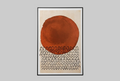A framed abstract art print leaning against a light gray wall on a gray surface. The artwork features a large textured terracotta orange-red circle above a dense row of black arch-like marks on a warm cream background.