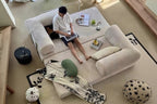 Person sitting on a large beige sofa in a modern living room.